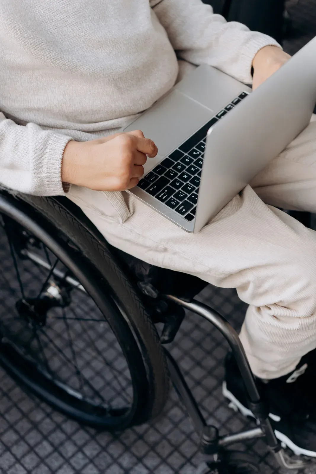 Persona en silla de ruedas utilizando un ordenador portátil.