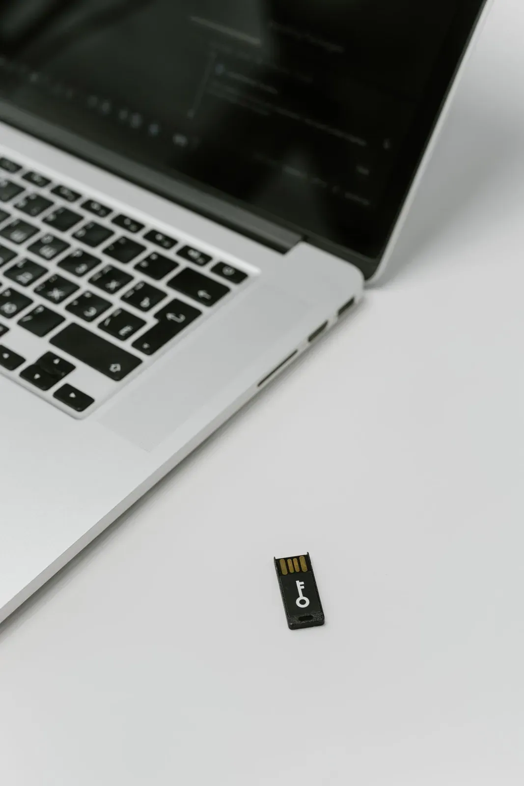 Llave de seguridad USB junto a un ordenador portátil.