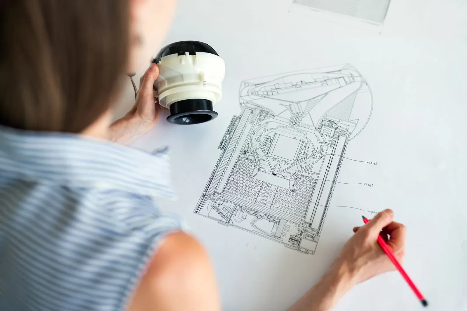 Ingeniera revisando un plano técnico en su mesa de trabajo.