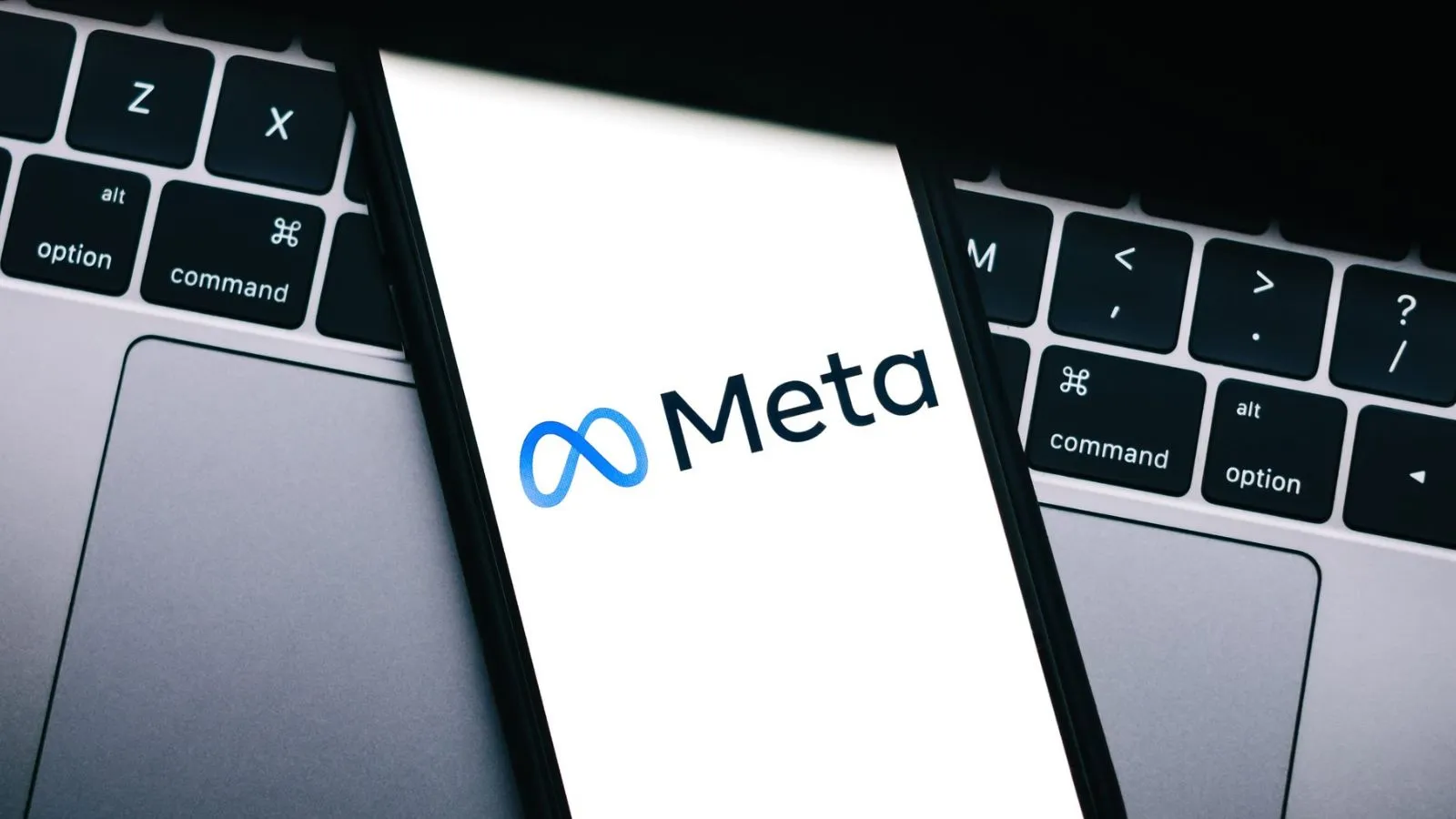 Fotografía editorial de un teléfono con el logotipo de Meta sobre un teclado