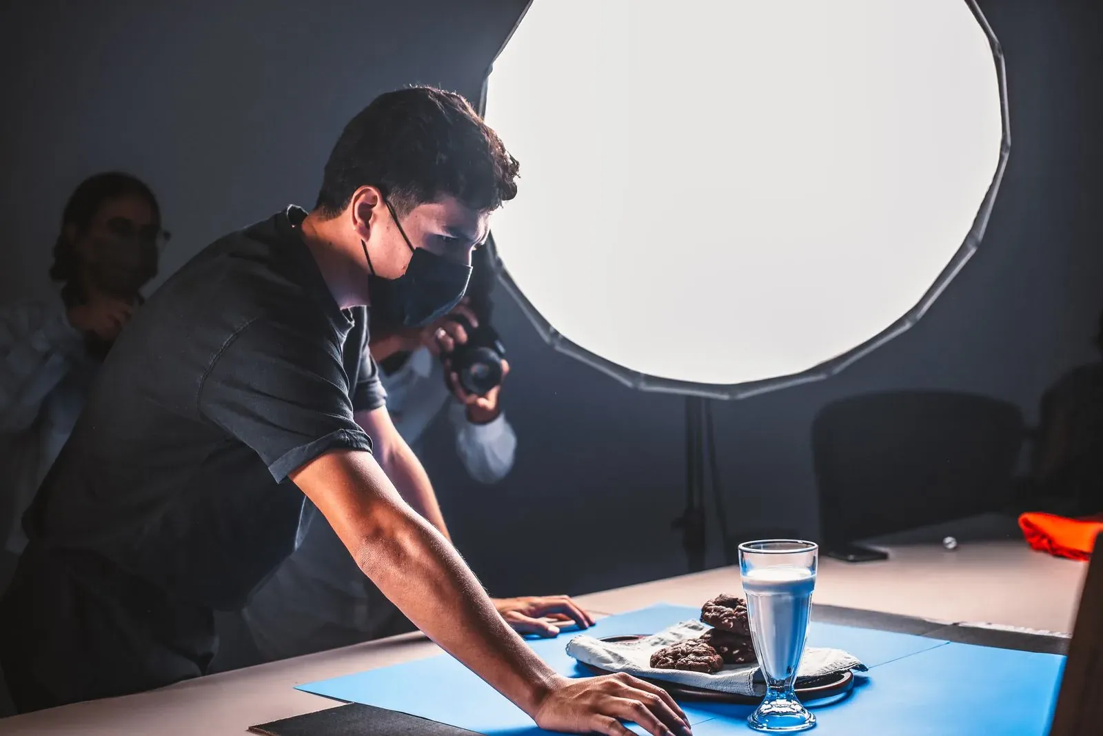 Equipo prepara una fotografía de producto con cámara, luces y fondo de estudio.