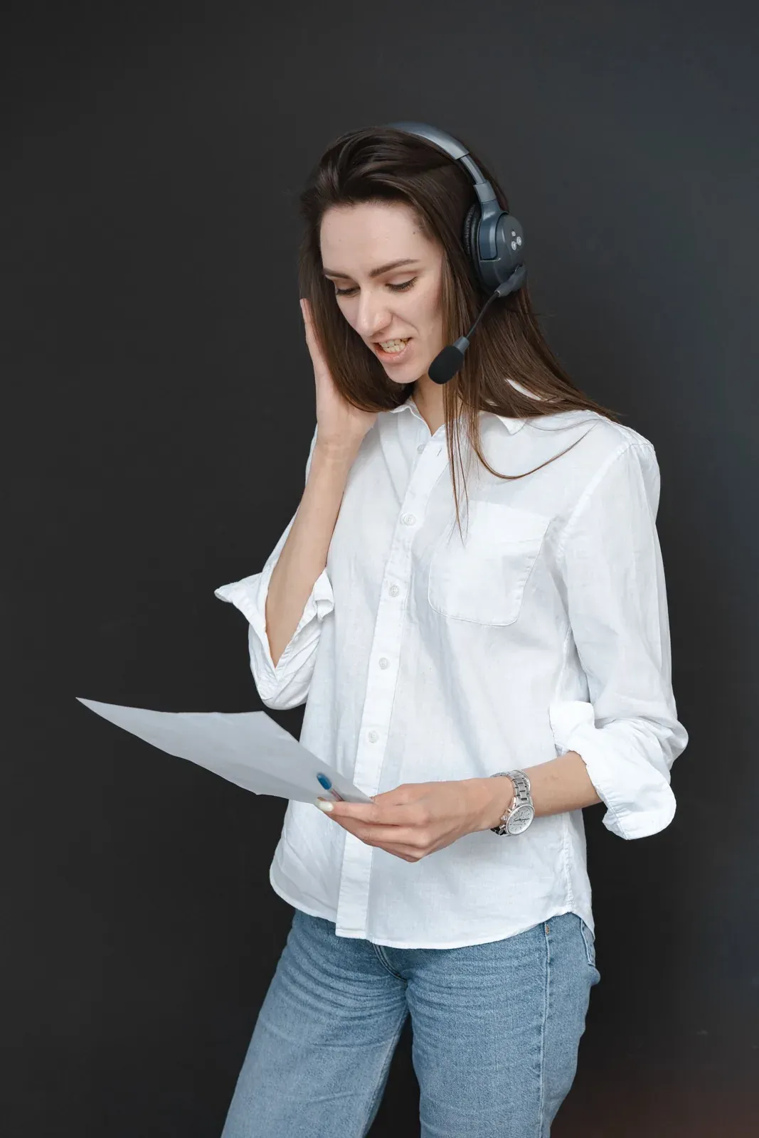 Profesional de atención revisando un documento con auriculares
