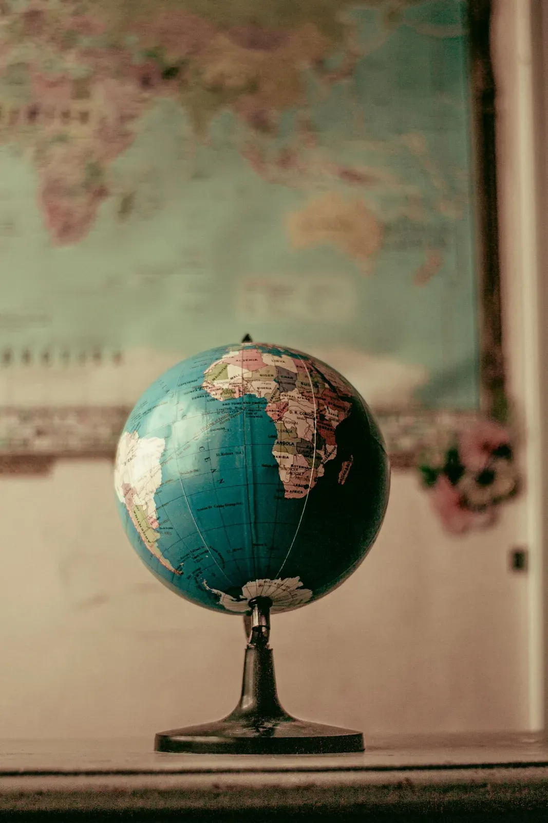 Globo terráqueo sobre una mesa frente a un mapa