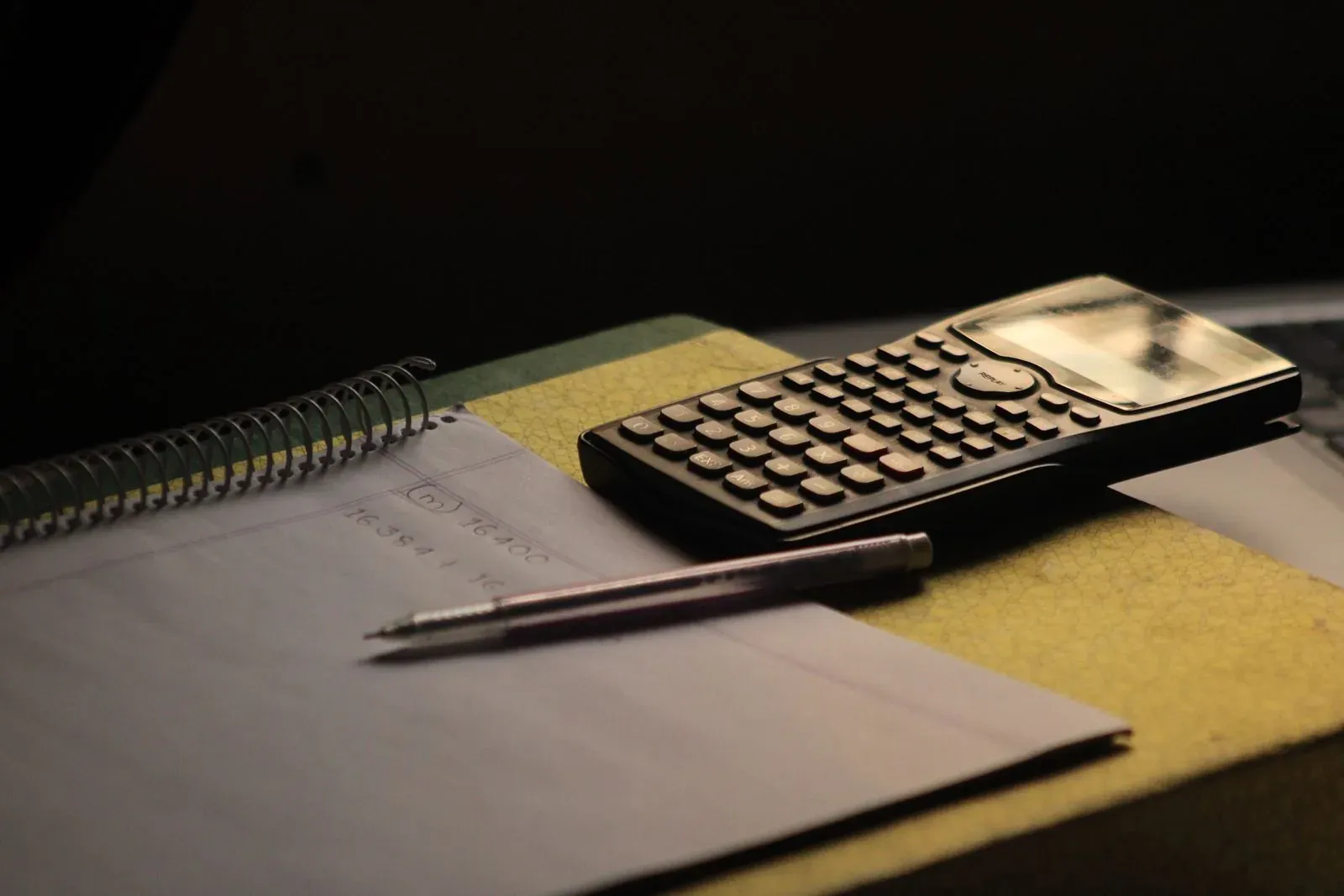 Calculadora junto a un cuaderno de trabajo