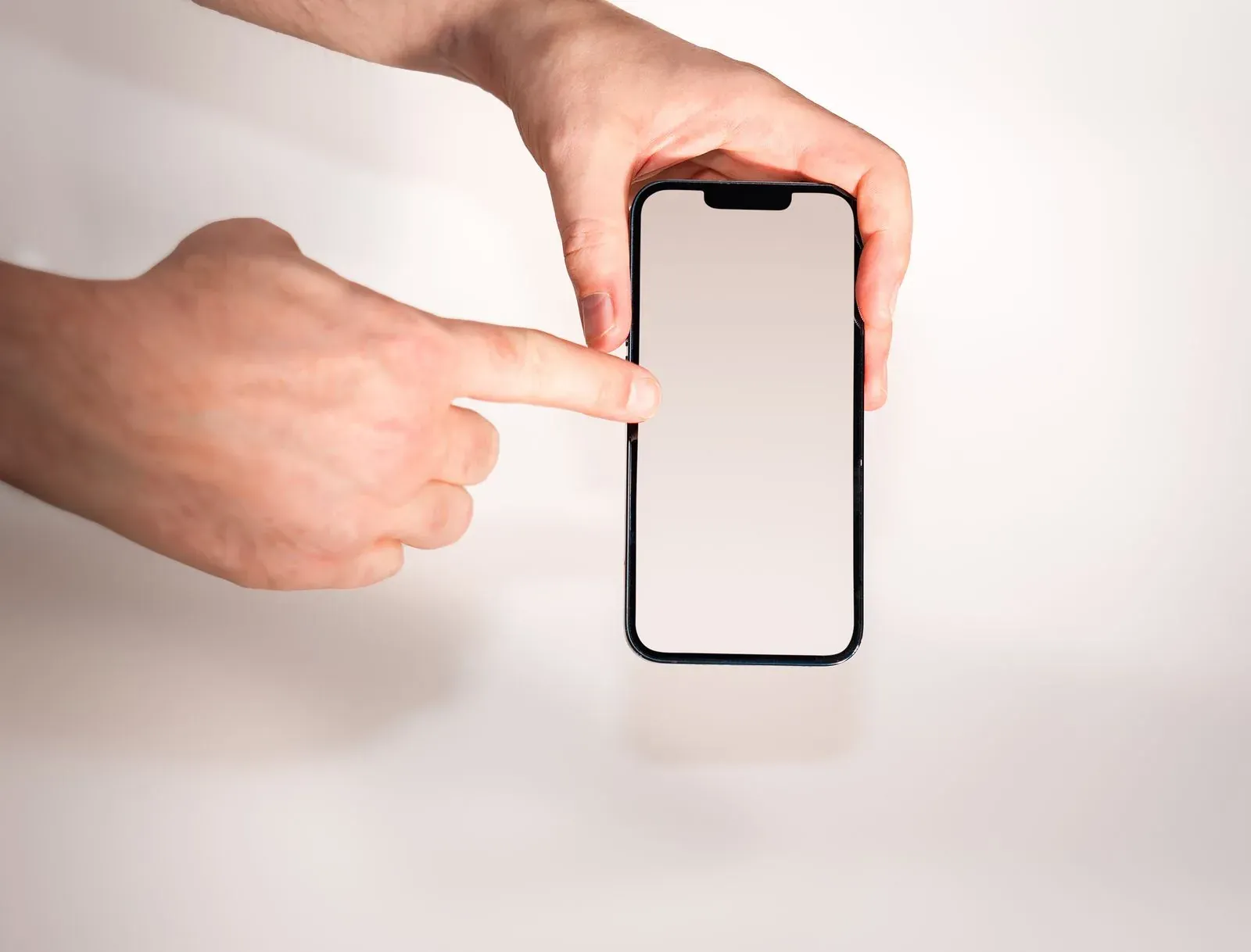 Mano señalando la pantalla de un teléfono móvil