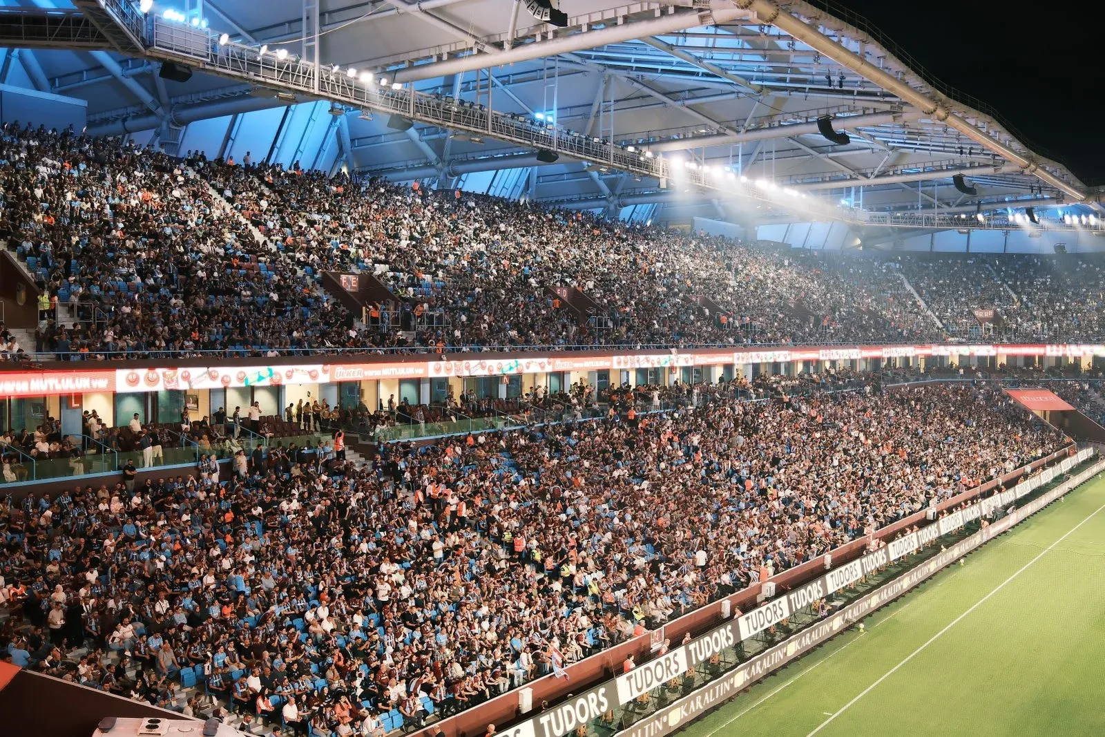 Un estadio de fútbol lleno durante un partido nocturno; foto de contexto tomada en Trabzon, no en el Bernabéu.