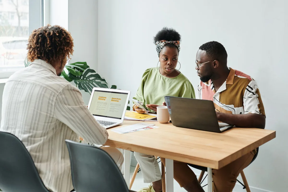 Tres profesionales revisan una propuesta digital alrededor de una mesa de trabajo